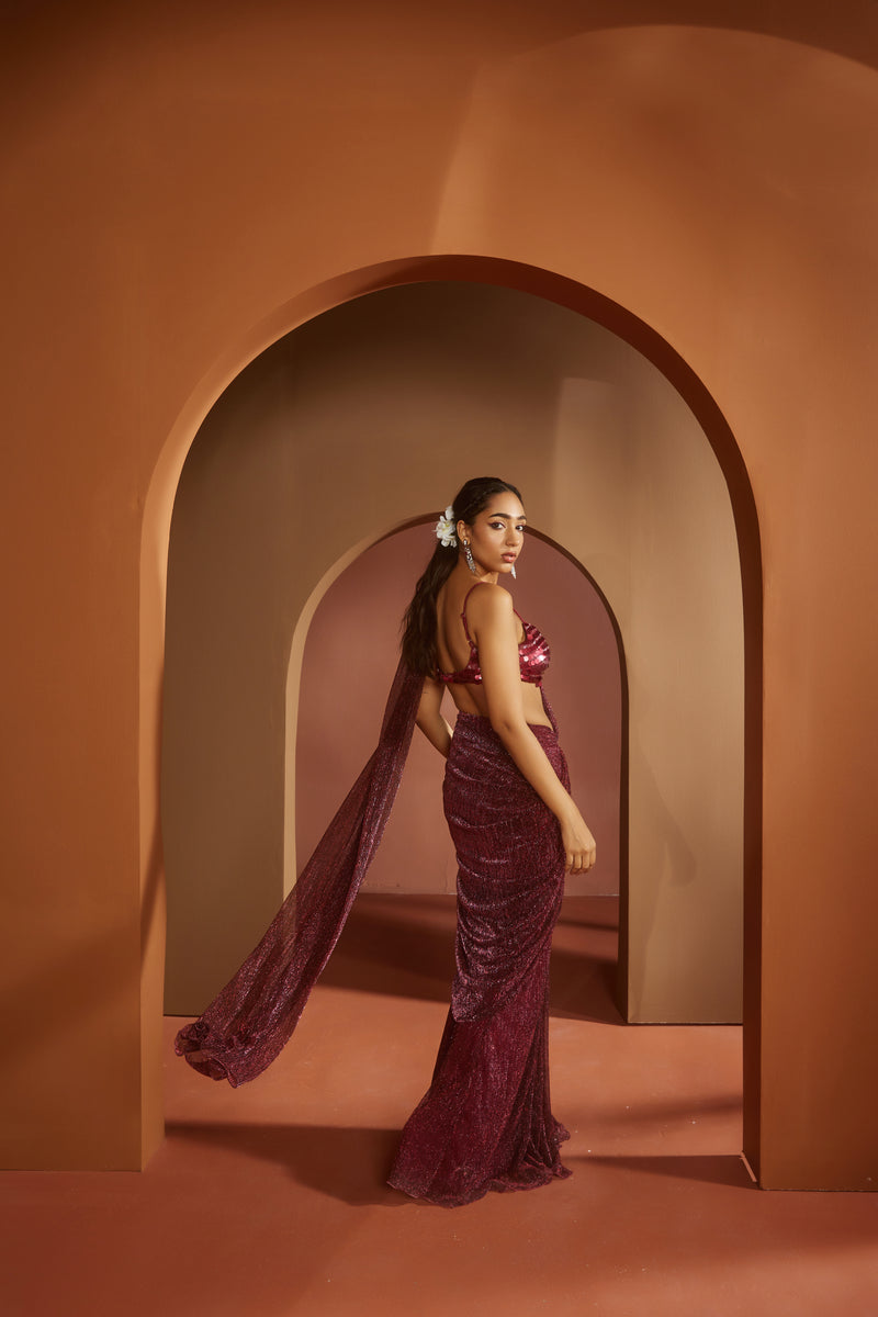 Chic woman in a Humaida Maroon Shimmer Pre-Draped Saree Set, exuding vibrant elegance