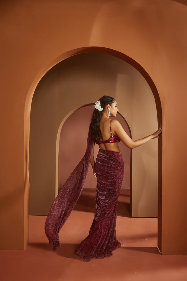 Chic woman in a Humaida Maroon Shimmer Pre-Draped Saree Set, exuding vibrant elegance