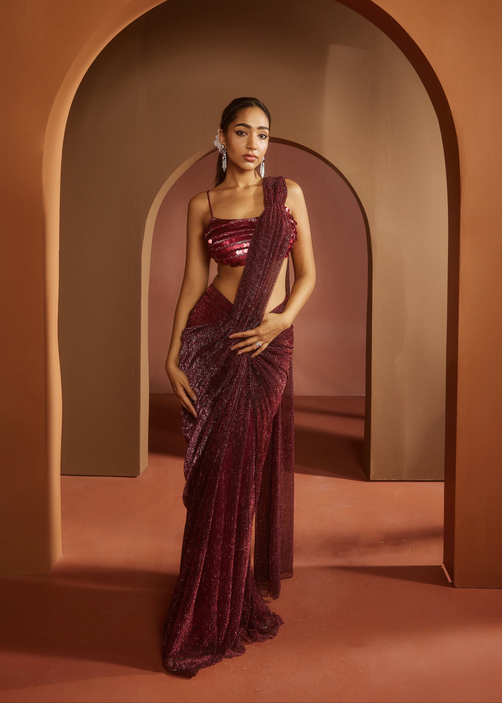 Chic woman in a Humaida Maroon Shimmer Pre-Draped Saree Set, exuding vibrant elegance