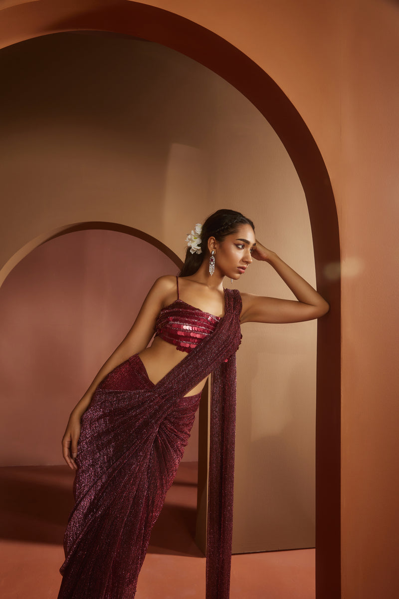 Chic woman in a Humaida Maroon Shimmer Pre-Draped Saree Set, exuding vibrant elegance