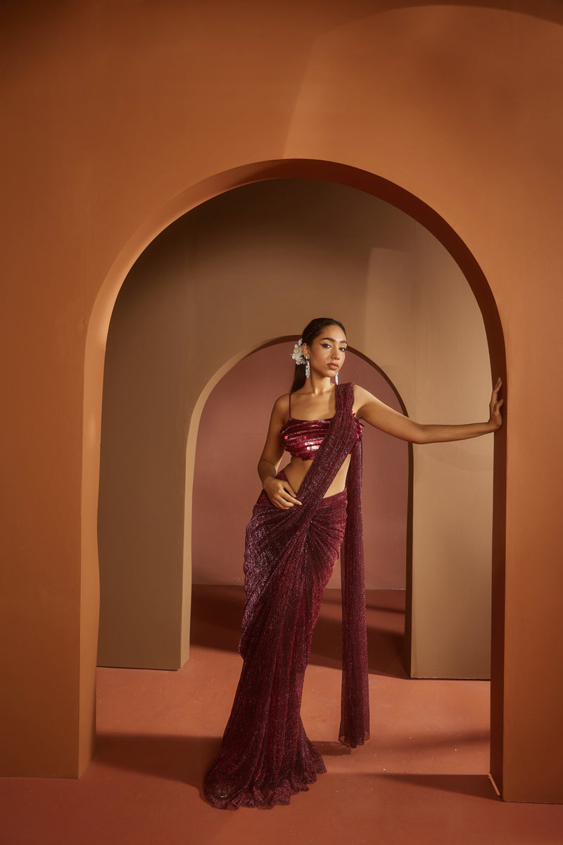 Chic woman in a Humaida Maroon Shimmer Pre-Draped Saree Set, exuding vibrant elegance