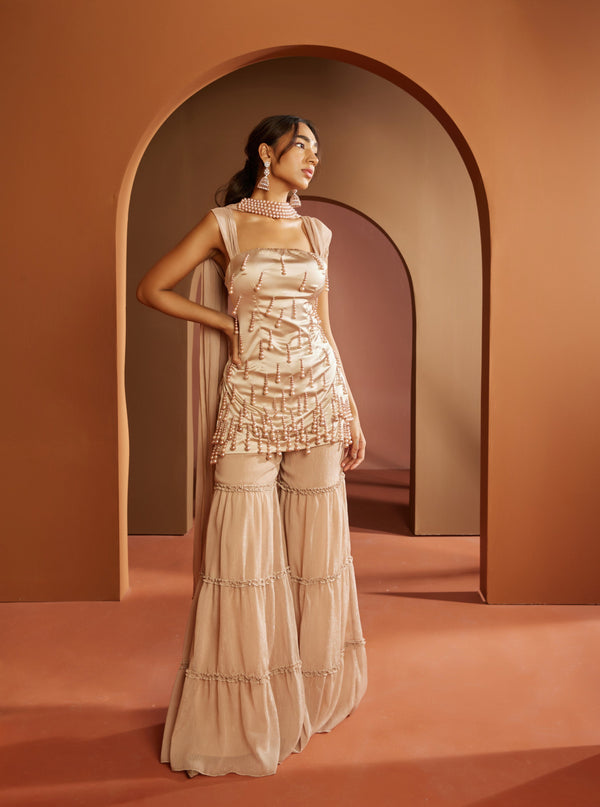 Graceful woman in a Janaki Champagne Pearl Embroidered Sharara Set, exuding timeless elegance and sophistication