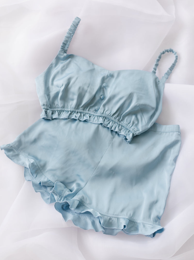 Chic woman in a Jane Baby Blue Satin Lounge Shorts Set, exuding relaxed and elegant style