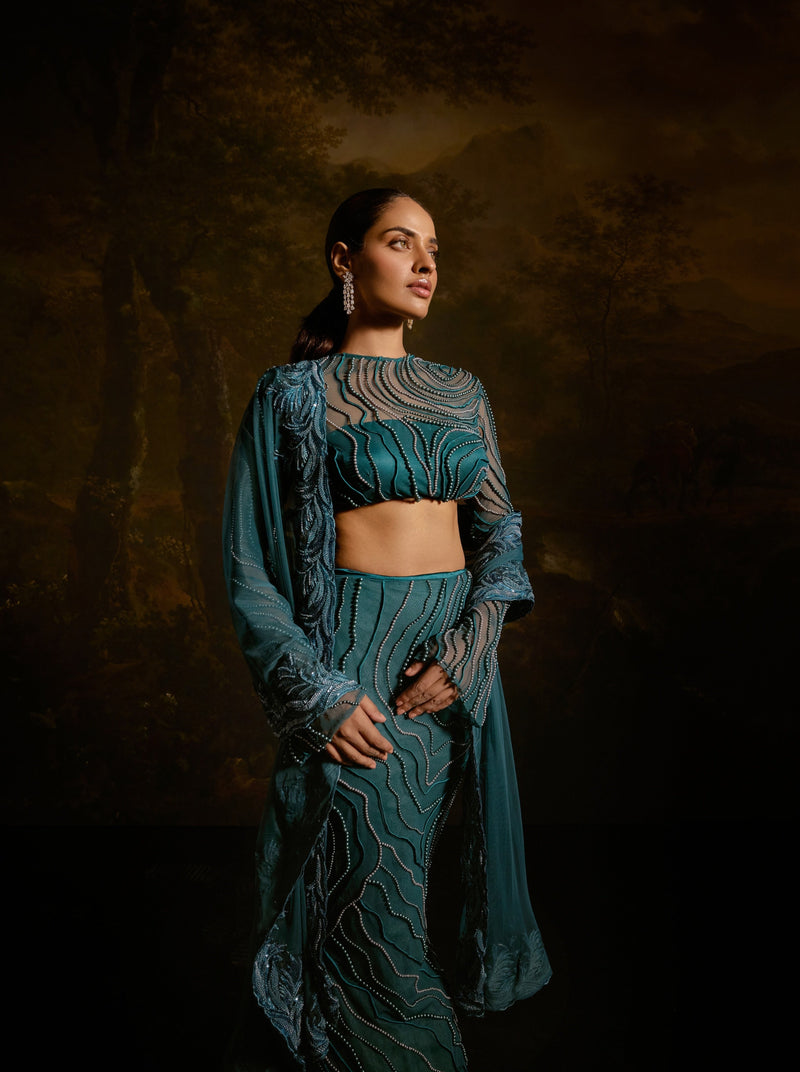 "Meera Teal Embroidered Lehenga Set: Teal lehenga set with intricate embroidery for a graceful and traditional appearance."