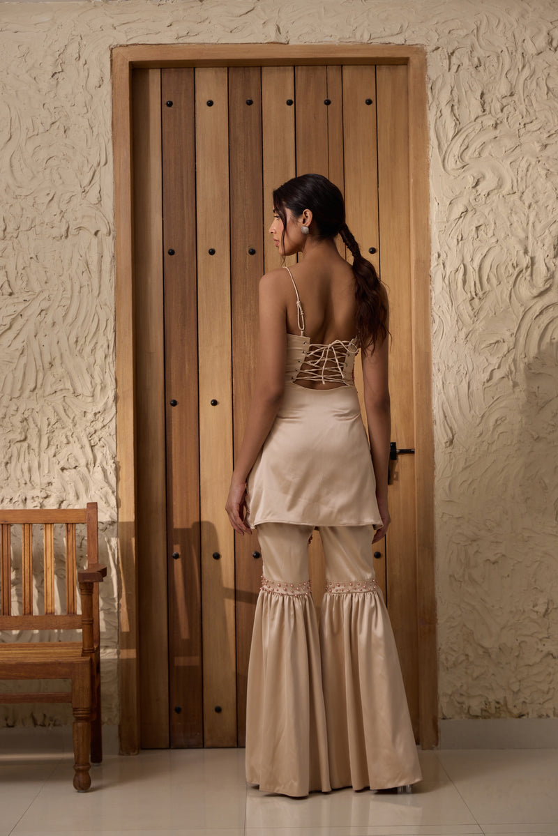 A champagne sharara set with hand-embroidered details.