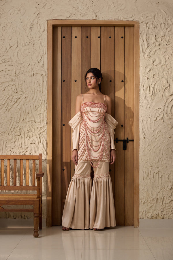 A champagne sharara set with hand-embroidered details.