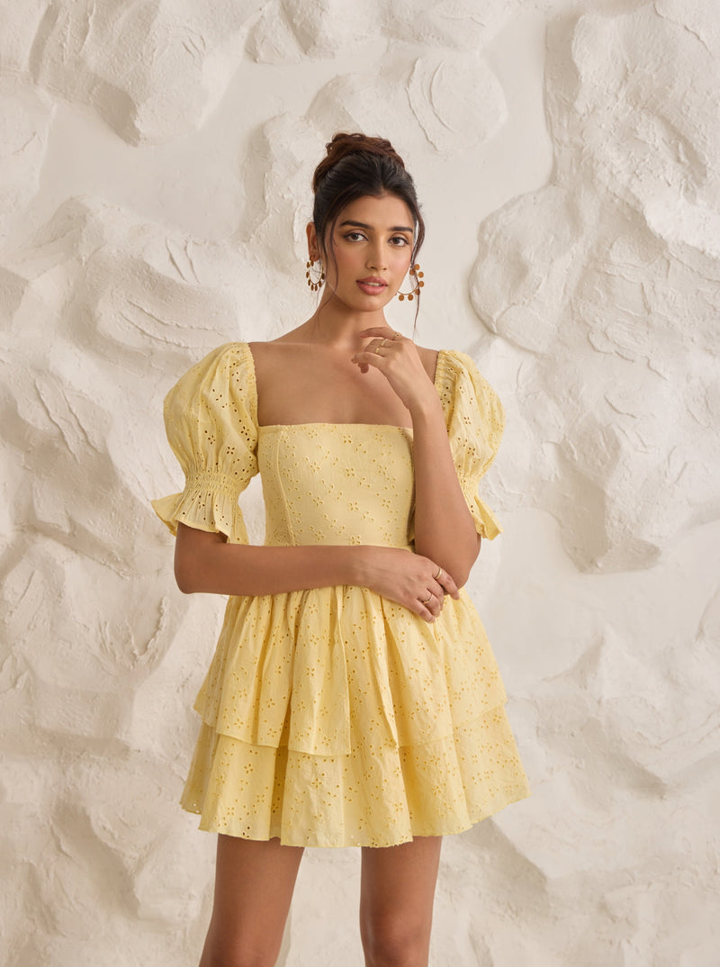 A vibrant Pixie yellow corset dress with Schiffli embroidery and puff sleeves.