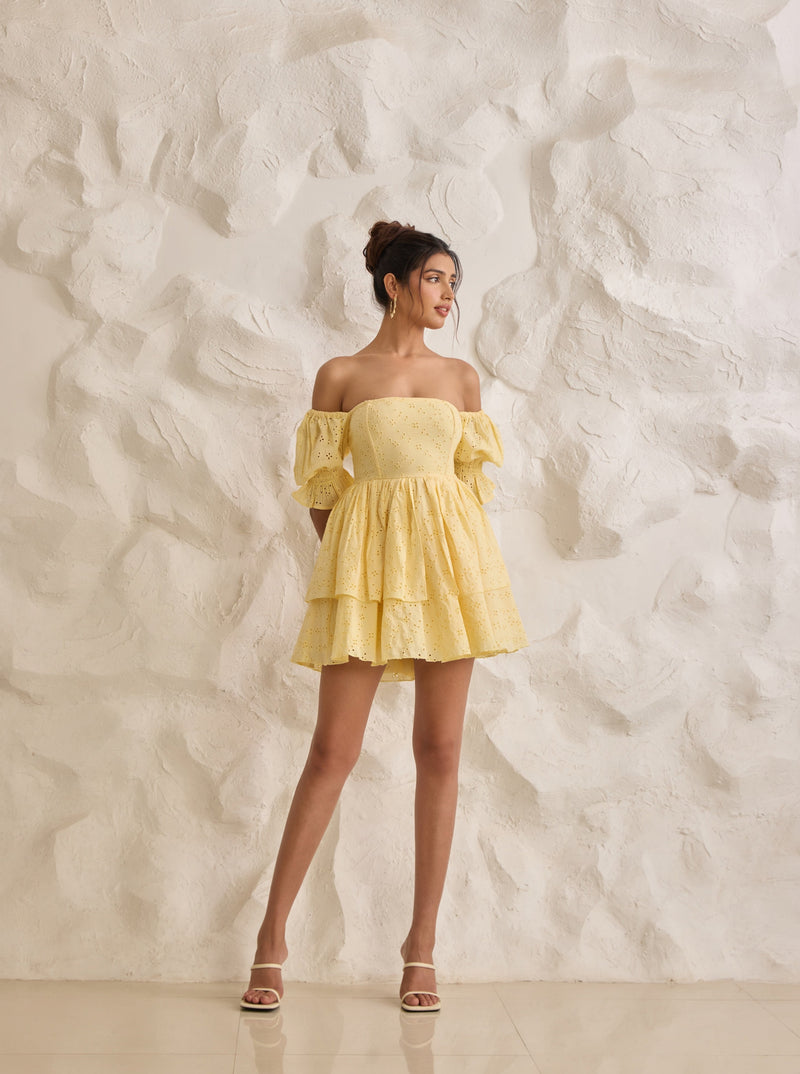 A vibrant Pixie yellow corset dress with Schiffli embroidery and puff sleeves.