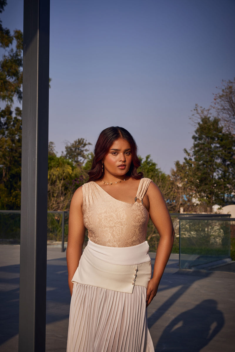 "Raegan Gold Asymmetric Bodysuit and White Pleated Maxi Skirt with a Contemporary Flair."