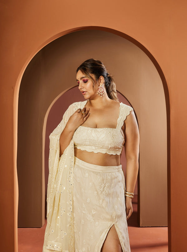 Graceful woman in a Vamika Ivory Embroidered Slit Lehenga, showcasing intricate elegance